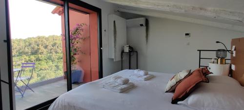 a bedroom with a bed and a large window at Mas des Buscades in Cabris