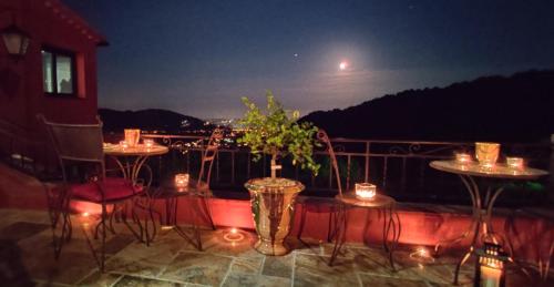 a balcony with tables and chairs at night at Mas des Buscades in Cabris