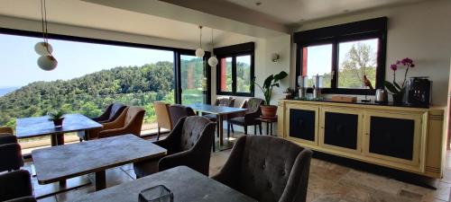 a restaurant with tables and chairs and a large window at Mas des Buscades in Cabris