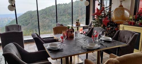 a dining room with a table and chairs and a christmas tree at Mas des Buscades in Cabris