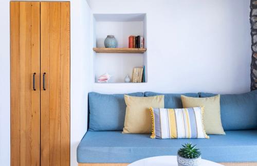 un canapé bleu avec des coussins dans un salon dans l'établissement Mochlos Waterside, à Mochlos