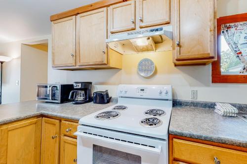 a white stove in a kitchen with wooden cabinets at Sherry Road Retreat in South Burlington