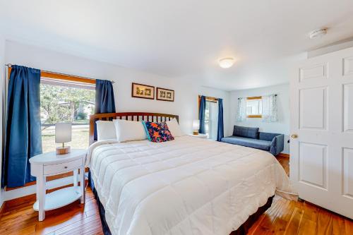 a bedroom with a large white bed and a window at Sherry Road Retreat in South Burlington