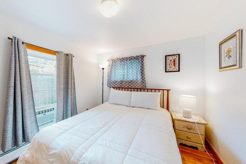 a bedroom with a white bed and a window at Sherry Road Retreat in South Burlington
