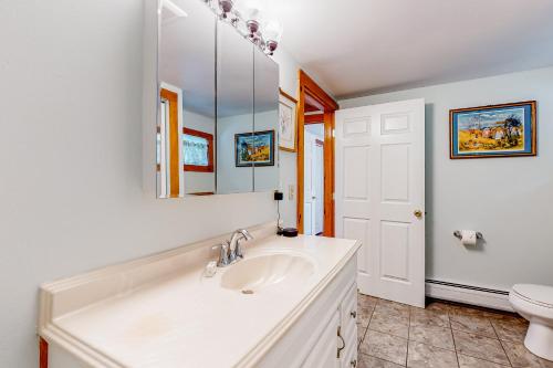 a bathroom with a sink and a toilet and a mirror at Sherry Road Retreat in South Burlington