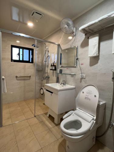 Un baño con inodoro, ducha y lavabo. en 西衛左岸觀海民宿, en Ch'ao-yang