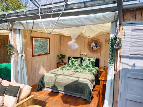 ein Schlafzimmer mit einem Bett und einem Baldachin in der Unterkunft Vrijstaande accommodatie Glamping de Kas InN in Hank