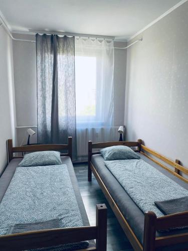 two beds in a room with a window at Füred Apartman in Balatonfüred