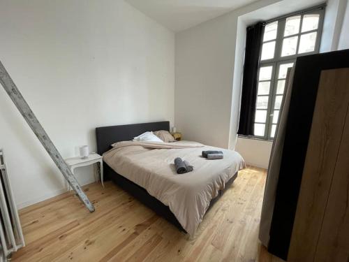sypialnia z łóżkiem i dużym oknem w obiekcie Superbe appartement lumineux w mieście Guéret