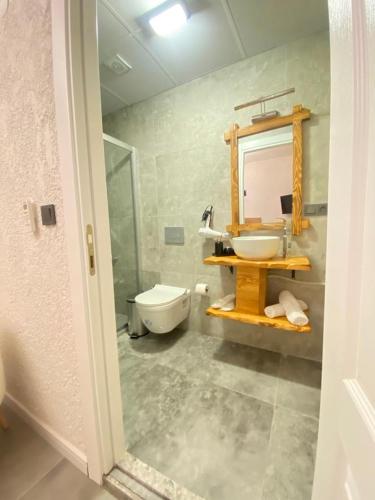 a bathroom with a sink and a toilet and a mirror at Armi Alaçatı in Cesme