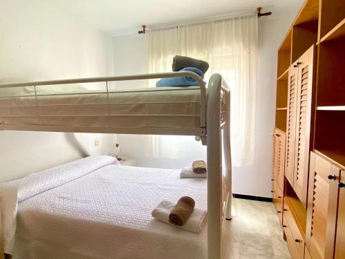 1 dormitorio con litera y toallas en Casa Bahia By Solymar Holiday, en Algarrobo Costa