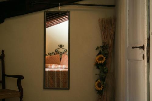 a mirror on a wall with a bed in a room at Locanda nel Cassero in Civitella Marittima