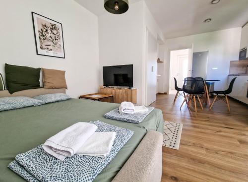 sypialnia z zielonym łóżkiem i salonem w obiekcie Villa Miss Sunshine with private jacuzzi w Novalji