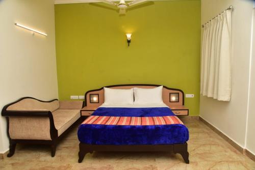 a bedroom with a bed and a chair at Calangute Residency in Calangute