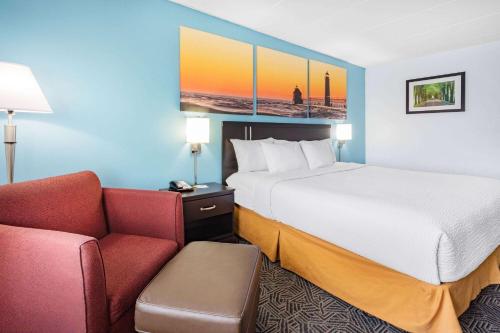 a hotel room with a bed and a couch at Days Inn by Wyndham Livonia Canton Detroit in Livonia