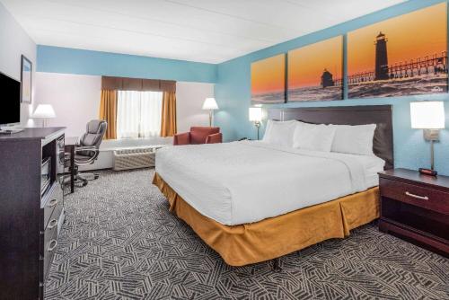 Habitación de hotel con cama y TV de pantalla plana. en Days Inn by Wyndham Livonia Canton Detroit en Livonia