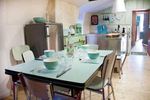 a kitchen with a table with plates and bowls on it at Gîte Philipeaux en centre-ville in Azay-le-Rideau