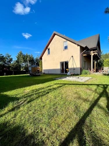 a house with a large grassy yard in front of it at Wigierska Osada 1 in Danowskie