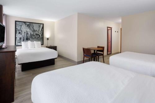 a hotel room with two beds and a table at Super 8 by Wyndham Quebec City in Quebec City