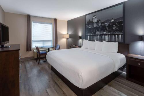 a hotel room with a large bed and a television at Super 8 by Wyndham Quebec City in Quebec City