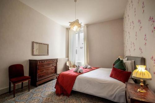 a bedroom with a large bed with a red blanket at Maison Eglantine YourHostHelper Classé 4* in Narbonne