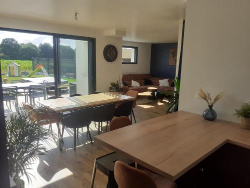 une pièce avec tables et chaises et un salon dans l'établissement Location maison 8 pers. avec spa - Morbihan, Theix, à Theix