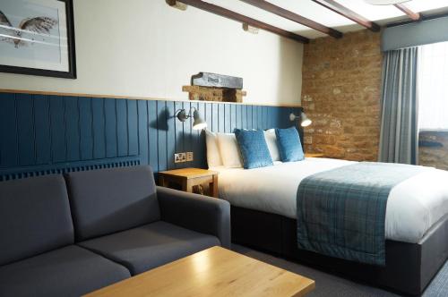 um quarto de hotel com uma cama e um sofá em Red Lion Hotel by Greene King Inns em Banbury