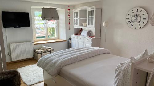 CourtedouxにあるHome Sweet Home by Stay Swissのベッドルーム1室(ベッド1台、壁掛け時計付)