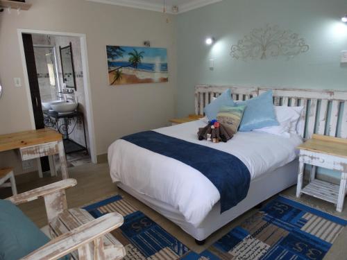 a bedroom with a bed with two teddy bears on it at Isle La Breeze Guest House in eMalahleni