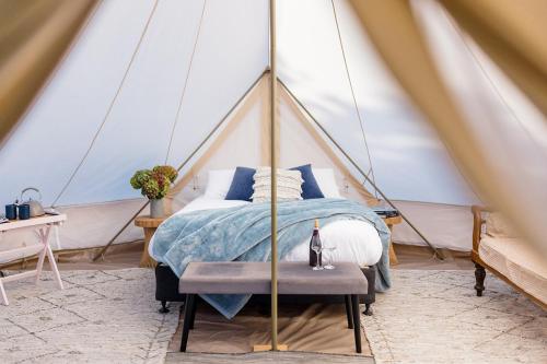 Goldfield Glamping في Clydesdale: غرفة نوم بسرير في خيمة