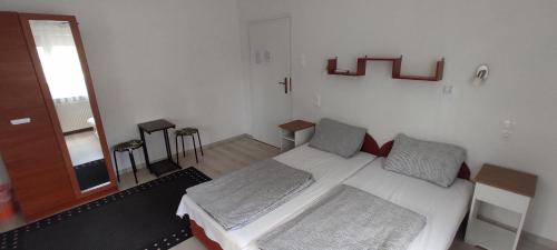 a bedroom with a white bed with two pillows at Timbi Vendégház in Vonyarcvashegy