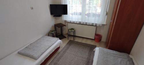 a small room with two beds and a window at Timbi Vendégház in Vonyarcvashegy