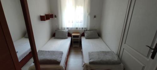 a hallway with three beds in a room with a window at Timbi Vendégház in Vonyarcvashegy