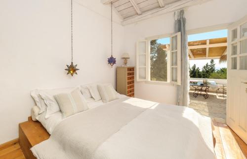 1 dormitorio blanco con 1 cama grande y patio en Villa Pelagia, en Arvanitakaíïka