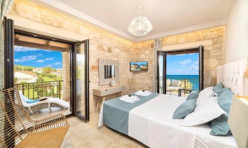 a bedroom with a bed and a balcony with the ocean at Psarou Beach House in Psarou