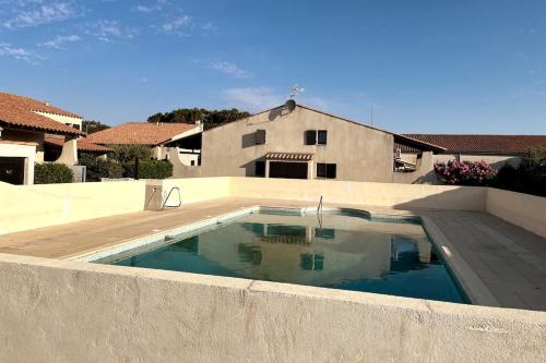 une piscine devant une maison dans l'établissement Maison climatisée avec piscine, terrasse et place de parking privative, à Saintes-Maries-de-la-Mer