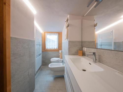 a white bathroom with a sink and a toilet at I Host Apartment - Centrale 16 in Piatta