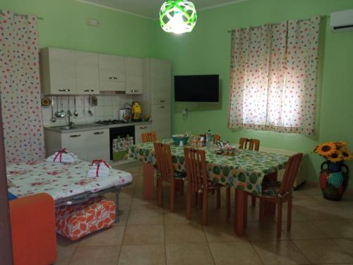 eine Küche und ein Esszimmer mit einem Tisch und Stühlen in der Unterkunft Rainbow Apartment in Scordia