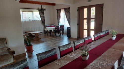 a row of chairs in a room with a table at Pensiunea Romosan in Cucuiş