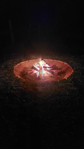 a woman standing in a fire pit at night at Pensiunea Romosan in Cucuiş