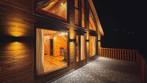 a balcony of a wooden house at night at Zivera Bungalov in Trabzon