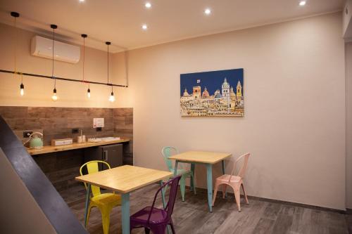 a restaurant with two tables and colorful chairs at Le Caravelle Affittacamere in Genova