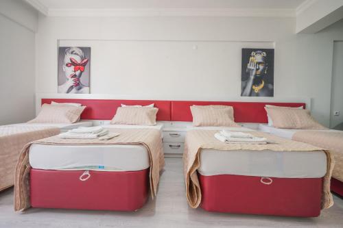 two beds in a room with red and white at YAŞAM HOTEL in Izmir