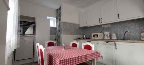 a kitchen with a table with a red and white table cloth at Timbi Vendégház in Vonyarcvashegy
