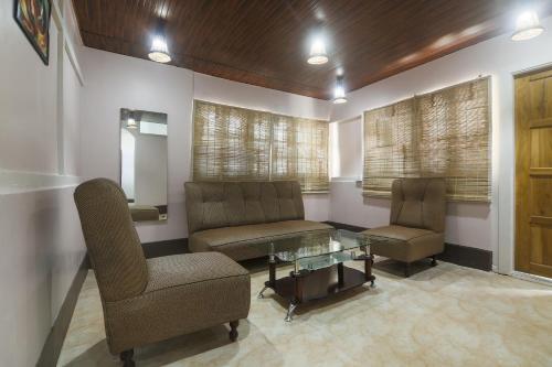 poczekalnia z 2 krzesłami i szklanym stołem w obiekcie Pillars House w mieście Shillong