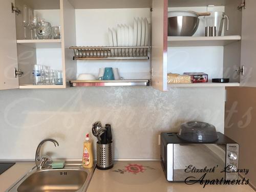 a kitchen counter with a sink and a microwave at Beachfront Luxury Apartments Elizabeth, Pomorie in Pomorie