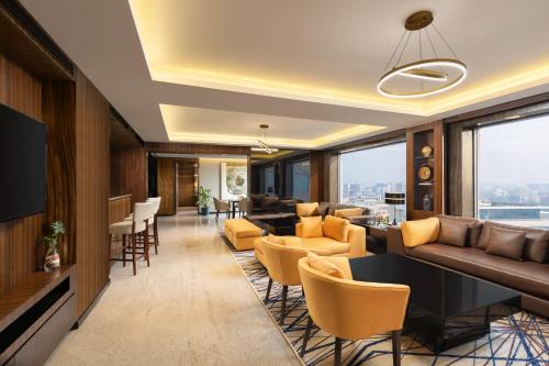a hotel lobby with couches and chairs and windows at Courtyard by Marriott Mumbai International Airport in Mumbai