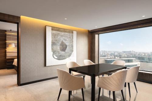 a dining room with a table and chairs and a window at Courtyard by Marriott Mumbai International Airport in Mumbai