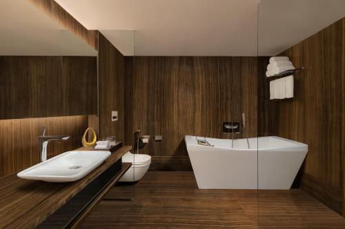 a bathroom with a white sink and a toilet at Courtyard by Marriott Mumbai International Airport in Mumbai