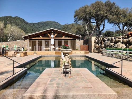 une maison avec une piscine et une fontaine dans l'établissement Appartement rénové tout confort 10mn de Campomoro, à Grossa